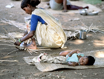 A basket weaver at work with her baby at her side, in Tamil Nadu. The infant mortality rate is very high for working women, particularly those in the primary sector, a large proportion of whom are labourers.